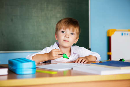 School and education concept. Little children at school lesson. Happy student writing in notebook in school classroom. Back to schoolの写真素材