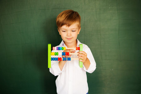 Young boy clever scientist children students with abacus and blackboard. Back to school concept.