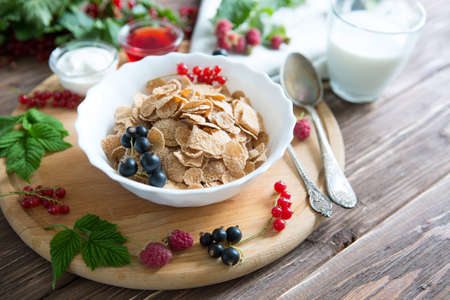 Breakfast Cereal, Table setting. Healthy tasty breakfast multigrain wholewheat healthy cereals with strawberries, raspberries, black currants and red currants.の写真素材