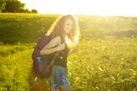 A world without borders. Stunning journey of girl in the mountains. woman traveler with backpack and hat walking in amazing mountains and forest, wanderlust travel conceptの写真素材