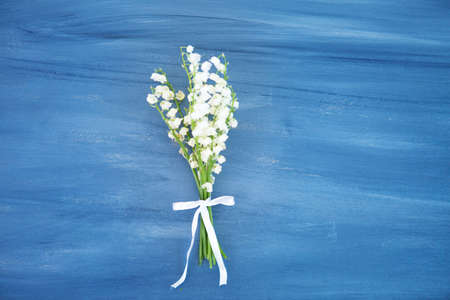 Wonderful fragrant white flowers with a delicate scent. Lily of the valley flowers on gray wooden or metal tableの写真素材