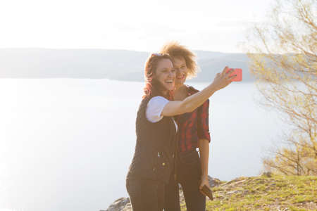 Two young women traveler makes selfie with sea viewの写真素材