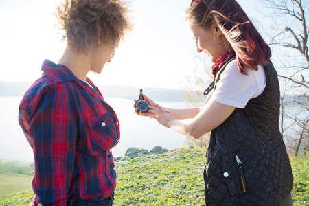 Two young tourist woman with compass hiking in mountain trailの写真素材