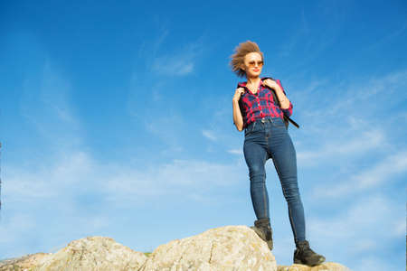Hiker with backpack relaxing on top of a mountain and enjoying sunrise. Woman on mountain in morning with vintage lightの写真素材