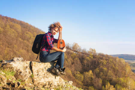 full of joyful feeling satisfaction for beautiful blonde young woman playing alone the acoustic guitar ukulele with the wind on his hair in summer time vacation leisure. pretty lady lifestyle.の写真素材
