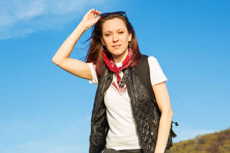 Beautiful girl Trist on top of a mountain on a background of sunset. Happy woman hiking in the woodsの写真素材