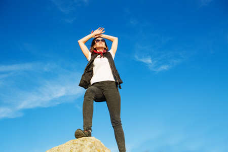 Hiker with backpack relaxing on top of a mountain and enjoying sunriseの写真素材