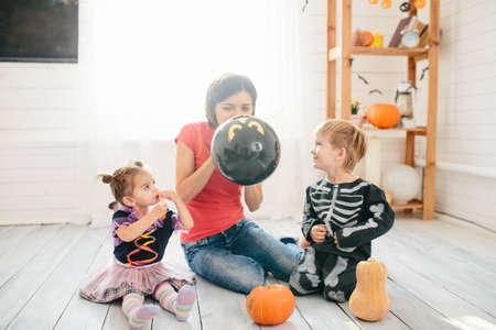Happy family of mother and children prepare for Halloween in decorate the homeの写真素材