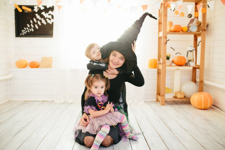 Happy family of mother and children prepare for Halloween in decorate the homeの写真素材