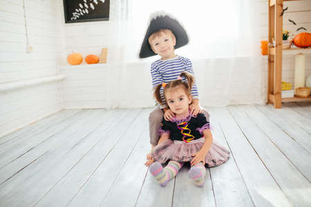 Boy in a pirate costume and a girl in a witch costume celebrates Halloween at homeの写真素材