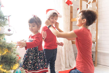 Mom with daughter and son wear santa hats for christmasの写真素材
