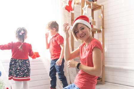 Mom with daughter and son wear santa hats for christmasの写真素材