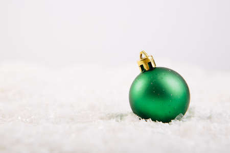 Christmas ball on snow over white backgroundの写真素材