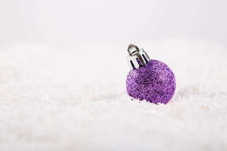 Christmas ball on snow over white backgroundの写真素材