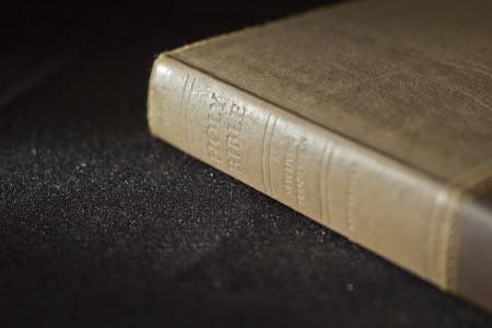 Holy Bible from the side on a black table clothの写真素材