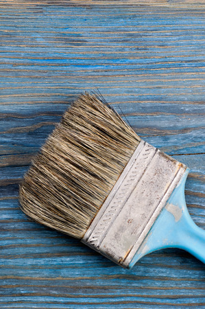 Used paint brush on blue rustic wooden board with place for textの写真素材