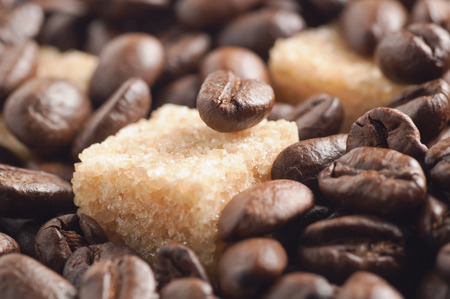 Cane sugar cubes covered by roasted coffee beans soft focusedの写真素材