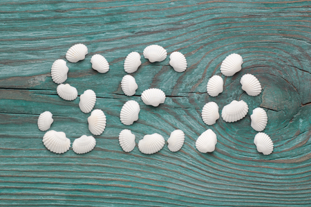 White sea shells forming word Sea on the old blue wooden board, view from aboveの写真素材