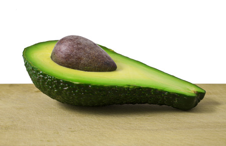 Ripe avocado on a wooden boardの写真素材