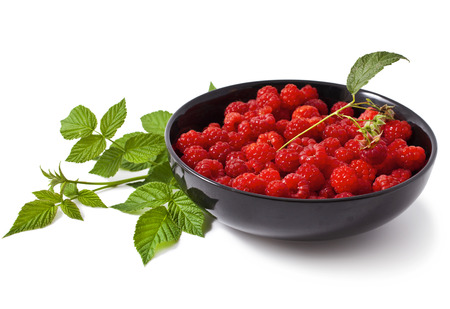 Red raspberries in a black bowl on a white backgroundの写真素材