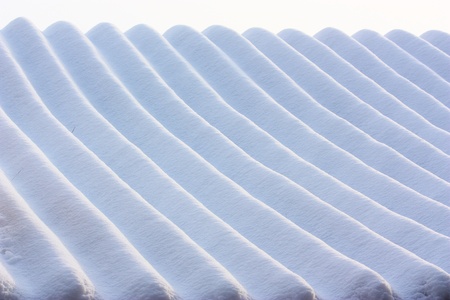 Lines in the snow made by a snowmobile,that was on the roof of buildings.Two branchs on the roof.の写真素材
