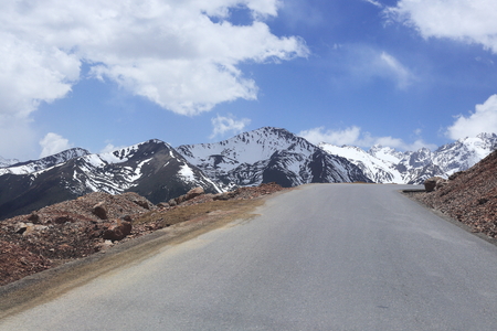 snow mountain with road in chinaの写真素材