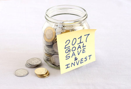 Concept of financial goal for the year 2017, highlighted with a handwritten note posted on a bottle...