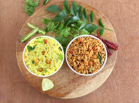 Lemon rice and puliyogare, two of the popular and traditional south Indian vegetarian breakfast on a...