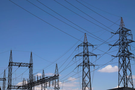 High voltage electrical towers against blue sky