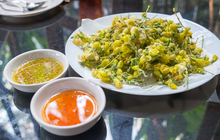 Sesbania flower fried egg on white plate and sauce two kindの写真素材