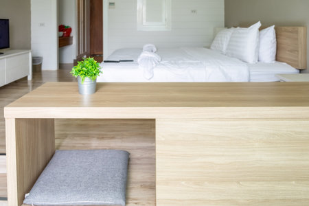 Wooden table with vintage vase plastic plant on bedroom