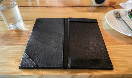 Black leather tray blank space payment bill on wooden tableの写真素材
