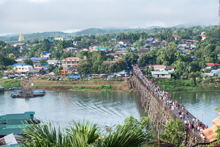 Tourists crowd travel on wooden mon bridge landmark in sangkhlaburi, kanchanaburi, thailandの写真素材