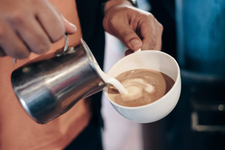 Barista pouring milk on coffee cup making heart shape