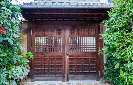 Ancient wooden door closed with green flora shady gardenの写真素材