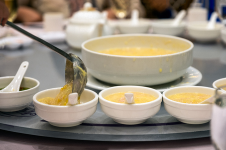 Spoon serving with corn soup on ceramic cup in restaurantの写真素材