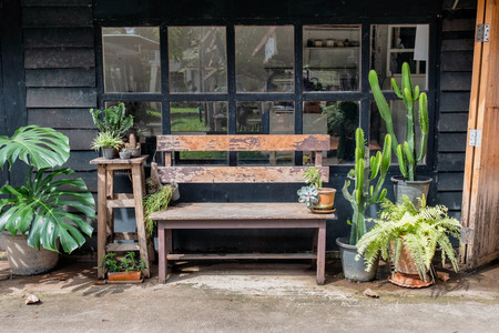 Wooden bench with green plant decoration at outside cafeの写真素材