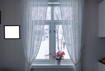 Interior of Pink flower on window sill with curtain and picture frame on winter seasonの写真素材