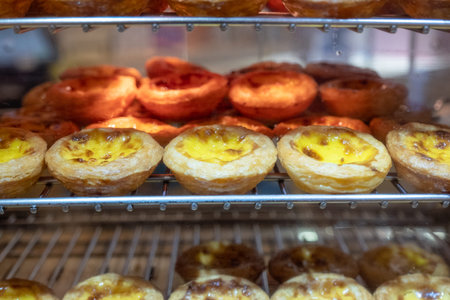 Egg tart with custard cream baking on grille. Sweet dessert traditional in Hong kong and Macau