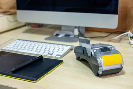 Payment terminal with intuos draw and computer screen on wooden desk