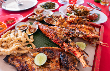 Seafood set with lobster, crab, fish, shrimp, shellfish on wooden tray in bali restaurantの写真素材
