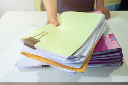 Man manager are filing account documents in front on white desk