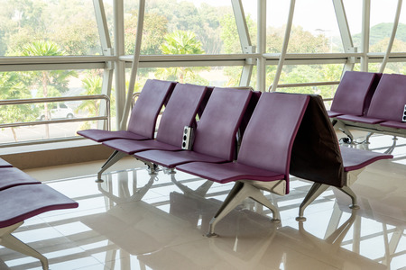 Purple rows chair with glass window at terminal gate in the airportの写真素材
