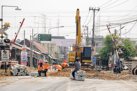 Kanchanaburi,Thailand - Mar 03 2016 : Backhoe and worker improvement construction of railwayのeditorial素材