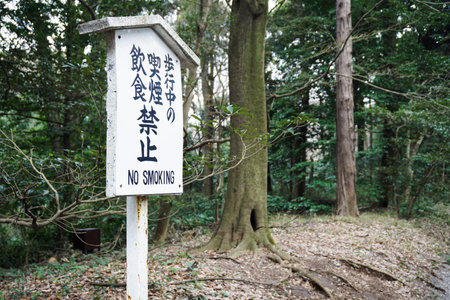 Kyoto,Japan - Mar 12 2016 : White signboard japanese font and english language message no smoking in parkのeditorial素材
