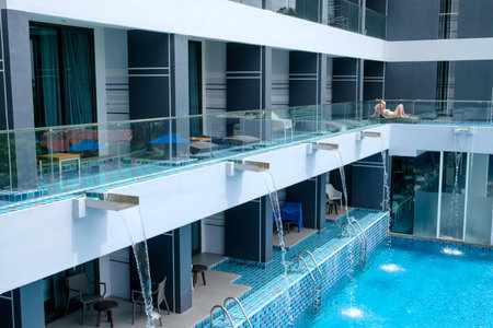 Phuket, Thailand - Apr 03 2017 : Hotel balcony and swimming pool and sunbathing tourists in the yama hotelのeditorial素材