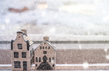 House ceramic decoration on window sill in snowing dayの写真素材