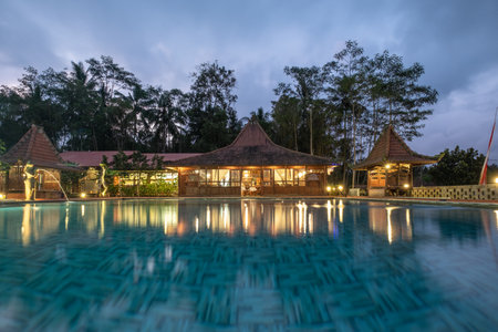 Banyuwangi, Indonesia - Architecture wooden resort bali style with swimming pool and illumination in dusk at Ijen islandのeditorial素材