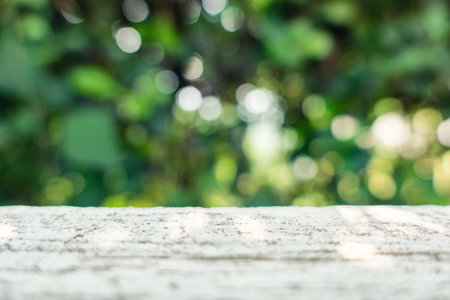 Cement table with blurred green plant with bokeh in garden background