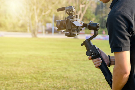 Professional videographer with camera on gimbal stabilizer for taking production